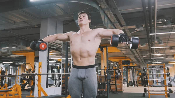 Muž sportovec zvedání činky bez košile v tělocvičně — Stock fotografie