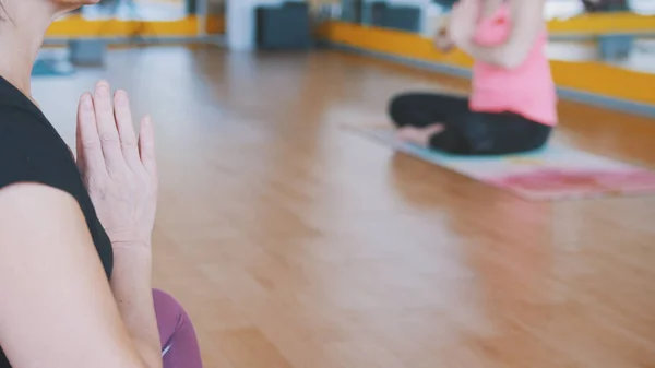 Coach visar lotus pose för grupp av kvinnor - yoga i gymmet — Stockfoto