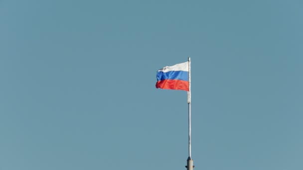 Le drapeau russe flotte dans le vent devant le ciel bleu — Video