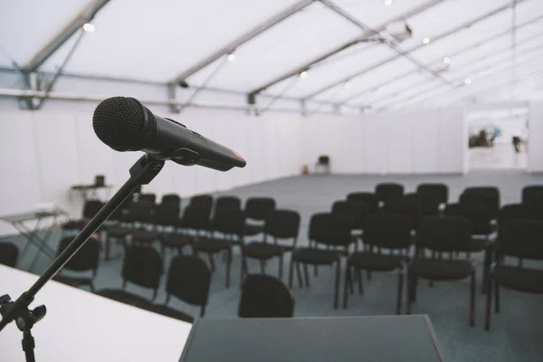 Svart mikrofon i konferensrum - tomma stolar på bakgrund — Stockfoto