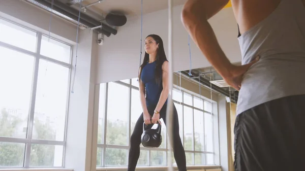 Frau trainiert Kniebeugen mit Gewichten im Fitnessstudio — Stockfoto