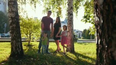 Yaz gecesi - baba, anne, kızı ve küçük çocuk, bir parkta sağlıklı aile