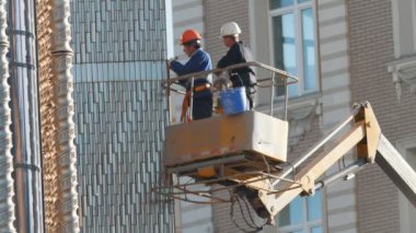 Kazan, Rusya Federasyonu - 15 Eylül 2017 - iki erkek işçi kamyon kule binasının cephe onarımı