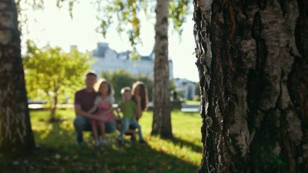 Здоровая семья в парке в летний вечер - отец, мама, дочь и маленький мальчик — стоковое видео