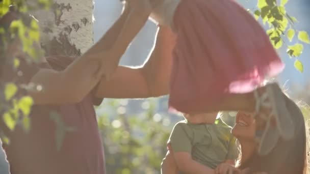 Famiglia felice - madre, padre e figli - nel parco la sera d'estate, al rallentatore — Video Stock