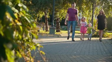 Yaz gecesi - baba, anne, kızı ve küçük çocuk, yavaş hareket, parkta mutlu aile