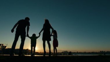 -Baba, anne, kızı ve küçük oğlu - aile günbatımı silüeti