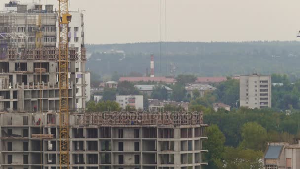 Lucrători în construcții pe șantier - construirea unui nou cartier de locuit, telephoto — Videoclip de stoc