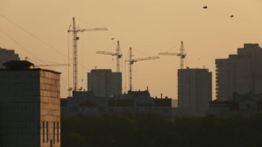 İnşaat alanında gündoğumu üzerinde inşaat vinçleri