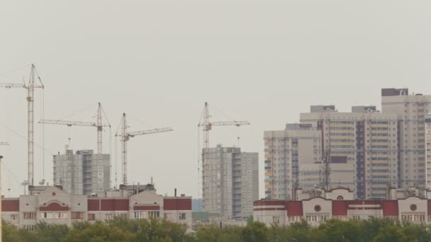 Casas residenciales - trabajadores en obra - construcción de un nuevo barrio habitable, teleobjetivo — Vídeo de stock