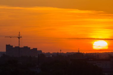 Şehir manzarası - kırmızı güneş, inşaat vinç, siluet üzerinde gündoğumu