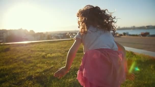 Menina criança está correndo, brincando e rindo, câmera lenta — Vídeo de Stock