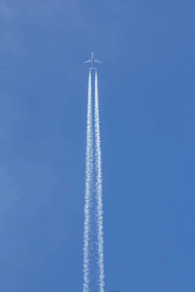 Jet is flying in the blue sky, vertical — Stock Photo, Image