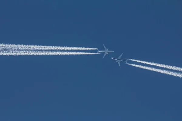 Due aerei passeggeri volano l'uno verso l'altro nel cielo blu — Foto Stock