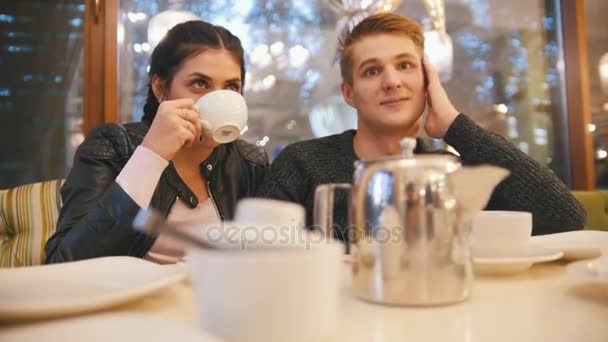 Портрет молодой счастливой пары - мужчина над женщиной в кафе — стоковое видео