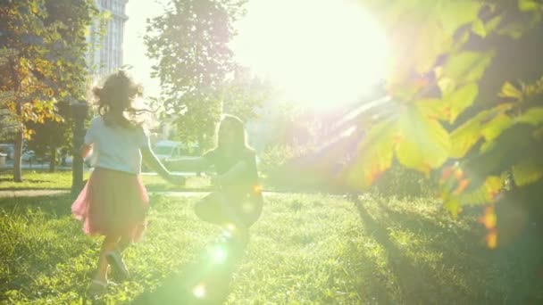 Jeune mère joue avec le petit fils dans le parc d'été au coucher du soleil au ralenti — Video