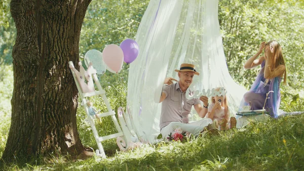 Une famille heureuse qui s'amuse en plein air dans un parc vert - mère, père et fille — Photo