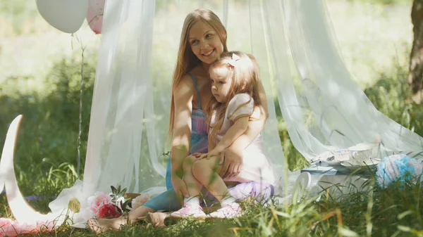 Embrasser mère et fille dans le parc - pique-nique et anniversaire — Photo