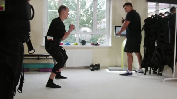 EMS - fitness instructeur werkt met atleet dragen pak van de ems - opleiding kalibratie — Stockvideo