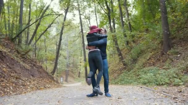 Романтическая пара в осеннем парке среди желтых листьев — стоковое видео