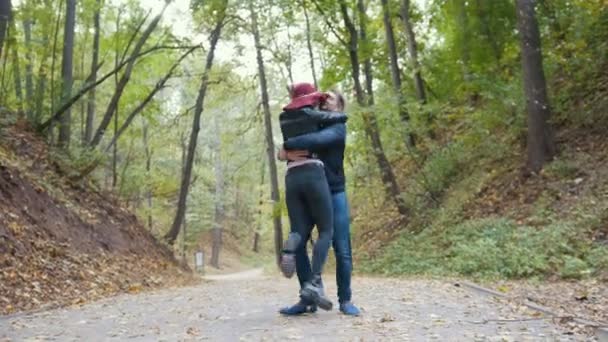 Pareja romántica en el parque de otoño entre hojas amarillas — Vídeos de Stock