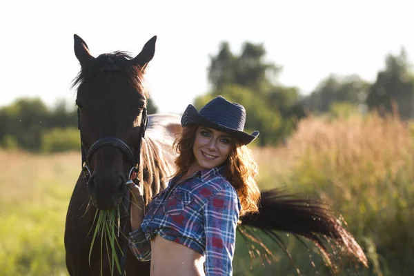 Mujer joven y caballo en el prado en la noche de verano — Foto de Stock