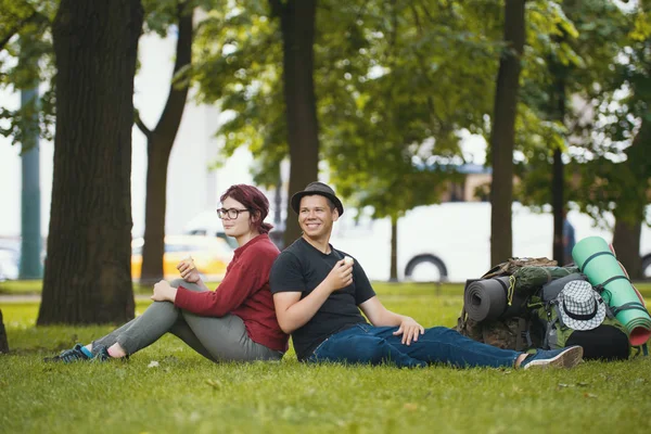 Подростки-туристы с рюкзаками едят мороженое в парке — стоковое фото