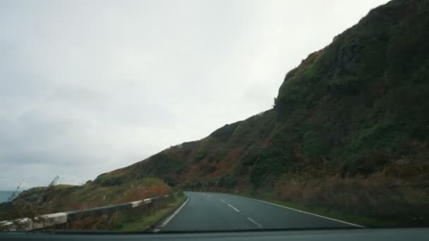 Carretera entre la costa rocosa cerca del mar en Escocia — Vídeos de Stock