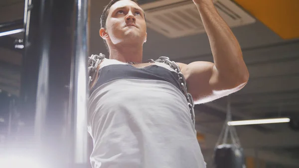 Bodybuilder - muscular man - in the gym performs pull up - close up — Stock Photo, Image