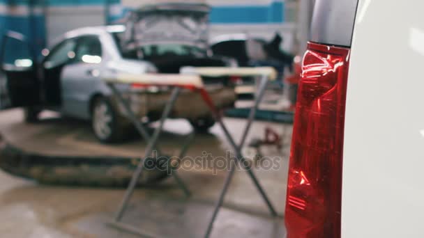 Servicio de coche - vehículo para la reparación de pie en el taller - tiro desenfocado — Vídeo de stock