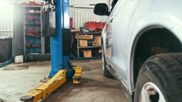 Autoservice - weißes Fahrzeug in der Werkstatt zur Reparatur oder Überprüfung — Stockvideo