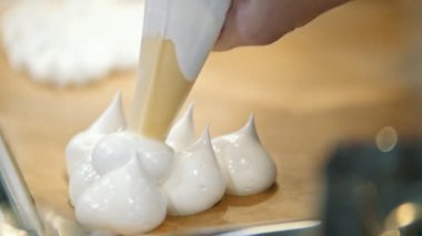 -Mutfakta şef pişirme beze pasta tüp beze bir fırın tepsisine - Pavlova tatlı yaymak.