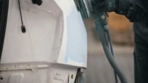 Работник автомастерской полирует автомобиль - готовится к покраске — стоковое видео