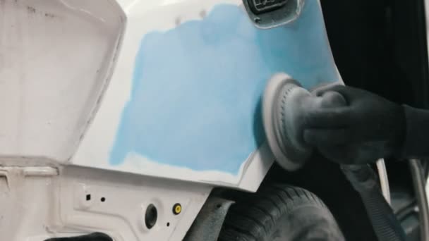 Працівник автомайстерні відполірує автомобіль - готується до малювання — стокове відео