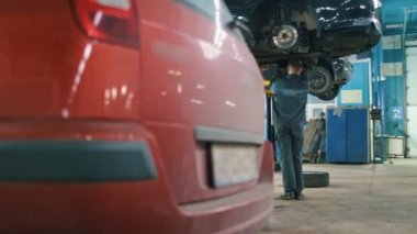 Otomobil garajındaki araba alt altında çalışan makinist erkek