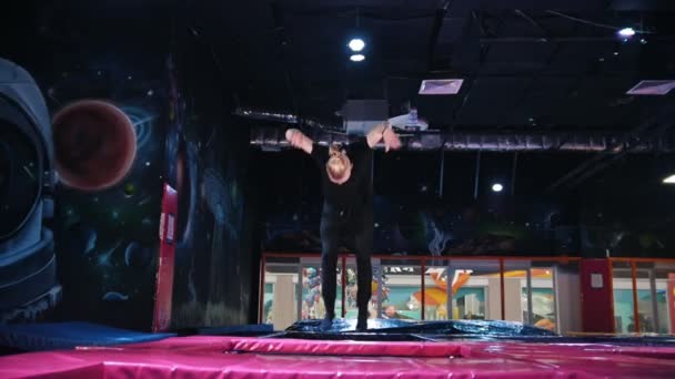 Young man doing a acrobatic jumps flip on trampoline — Stock Video