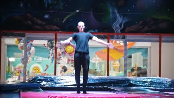 Junger Mann macht akrobatische Sprünge auf Trampolin — Stockvideo