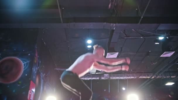 Jonge gespierde man topless acrobat springen op de trampoline - vertraagd, tele — Stockvideo