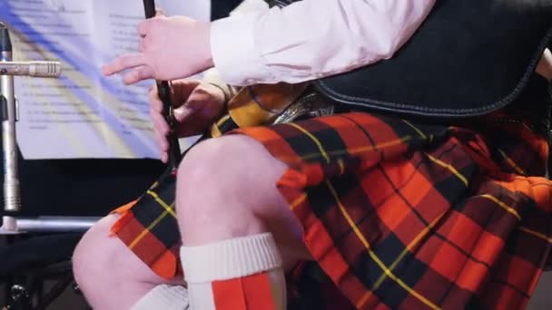 Barbudo hombre en la falda escocesa juega pipa en el escenario — Vídeos de Stock