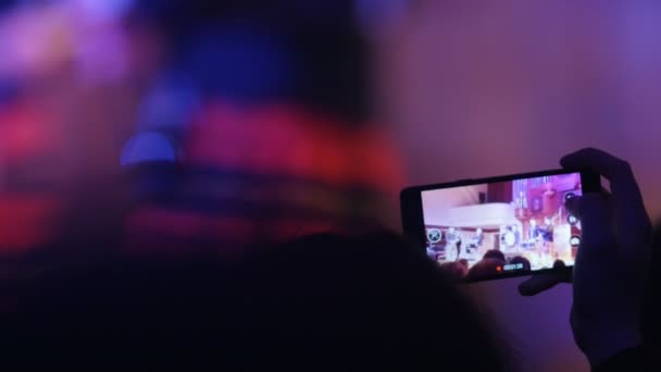 Зрители на концерте снимали видеовыступление на смартфоне, шотландских музыкантов — стоковое видео