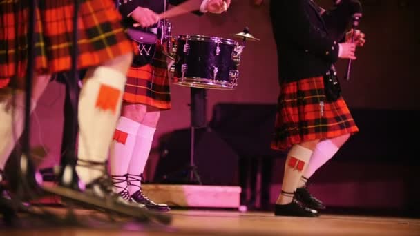 Músicos tradicionales de bandas escocesas en calcetines blancos y escoceses cantando con gaitas en el escenario — Vídeos de Stock