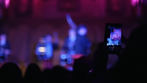 Зрители на концерте - люди снимают вертикальное видео на смартфоне, шотландские музыканты — стоковое видео