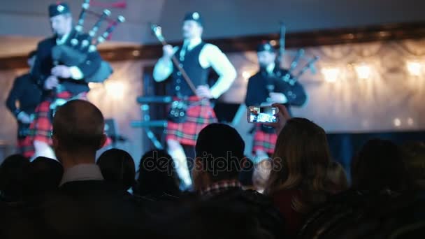 Espectadores en concierto - gente grabando actuaciones en teléfonos inteligentes, músicos escoceses — Vídeo de stock