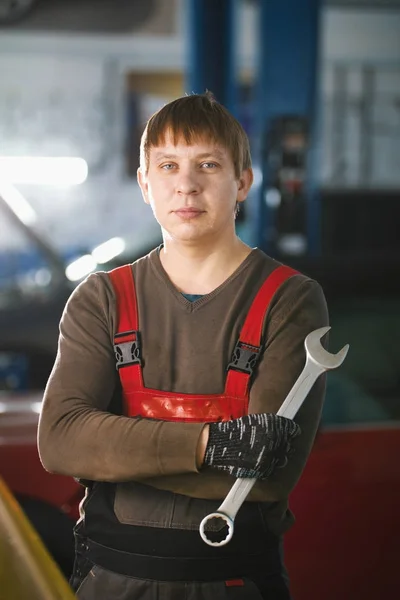 Portrait of a young car mechanic in a car workshop — Stock Photo, Image