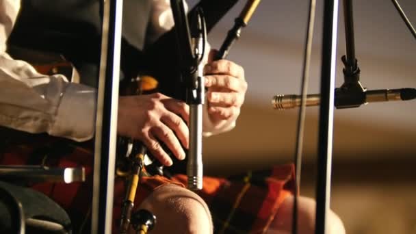 Bagpipe player em um kilt toca instrumento musical no palco — Vídeo de Stock