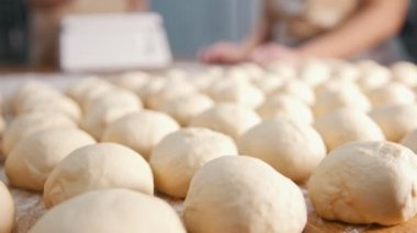 Şef hamur kabartma, tahtada çiğ hamur parçalarını hazırlar