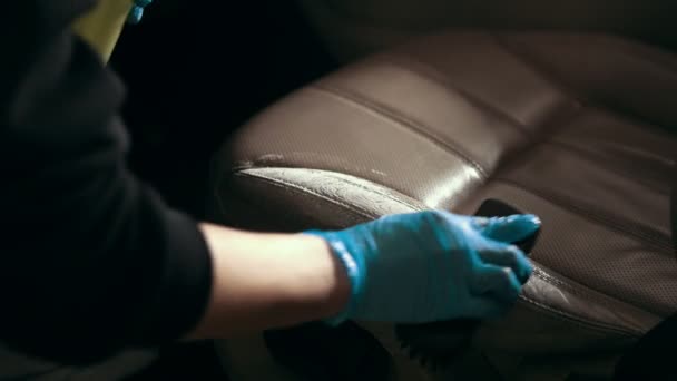 Worker in gloves is washing with brush a car seats — Stock Video