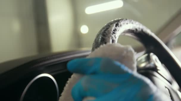 Працівник в рукавичках миє інтер'єр автомобіля і кермо — стокове відео