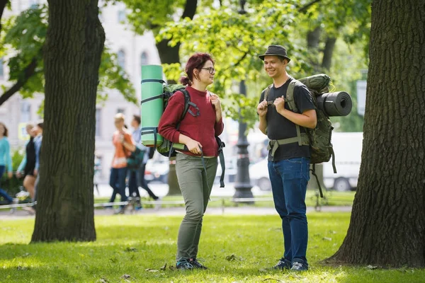 Adolescentes turistas con mochilas de pie en el parque al mediodía de verano —  Fotos de Stock