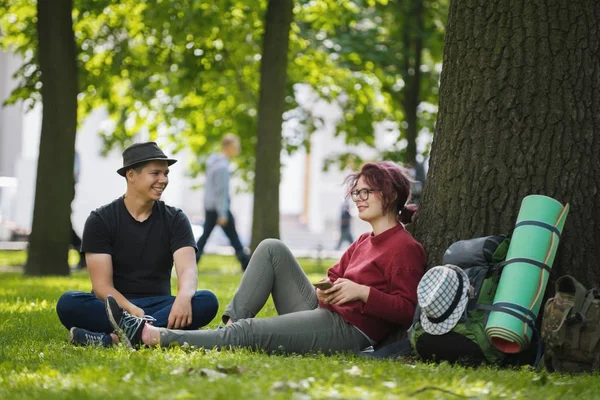 Gençler turistler yaz öğle anda parkta sırt çantaları ile